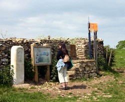 Interpretation panel, monument and stile on eastern side of plateau edge
