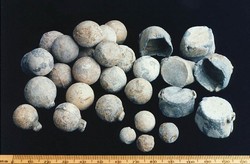 Lead bullets of varying calibre, some still with sprews attached, together with powder box caps.